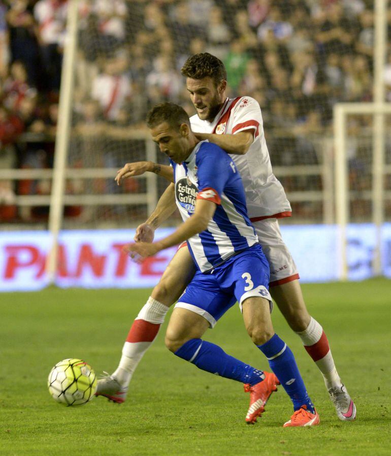 El defensa del Deportivo, Fernando Navarro, disputa un balón con el jugador del Rayo Vallecano, Quini