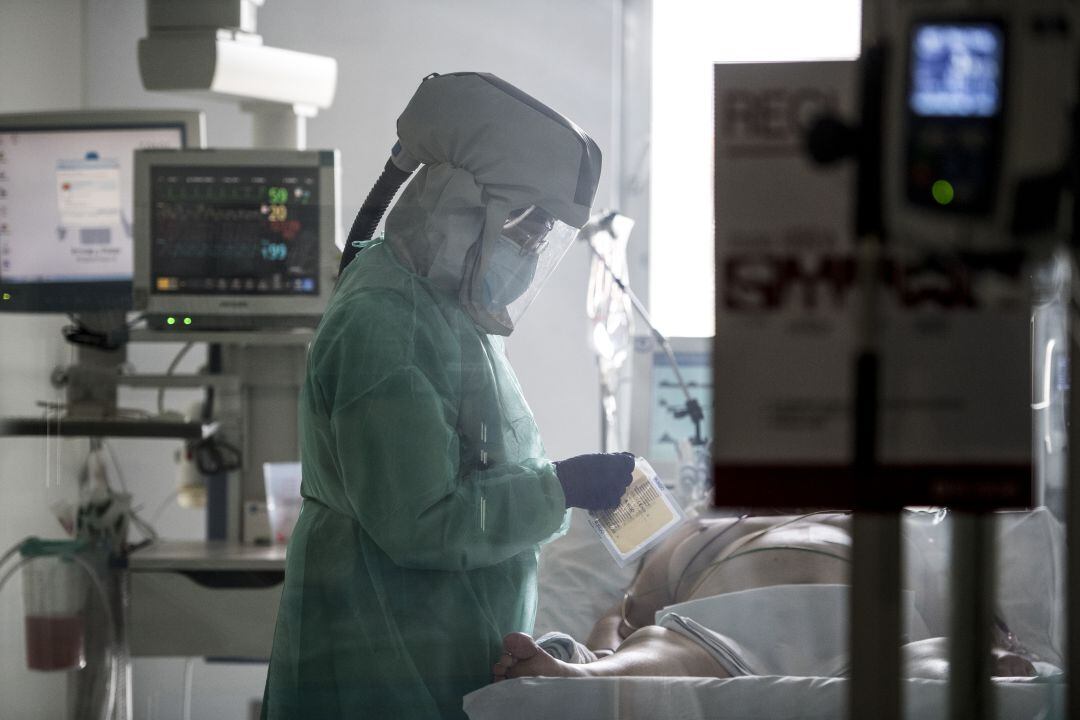 Una enfermera con un paciente de coronavirus en la UCI.