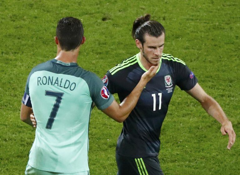 Cristiano Ronaldo y Gareth Bale se saludan durante un lance del juego.