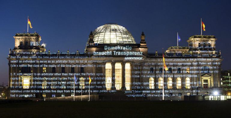 Extractos del las negociaciones entre EE.UU. y la UE del Acuerdo de libre comercio y de inversiones (TTIP) proyectados en la fachada del Parlamento alemán en Berlín (Alemania) en la madrugada de hoy.