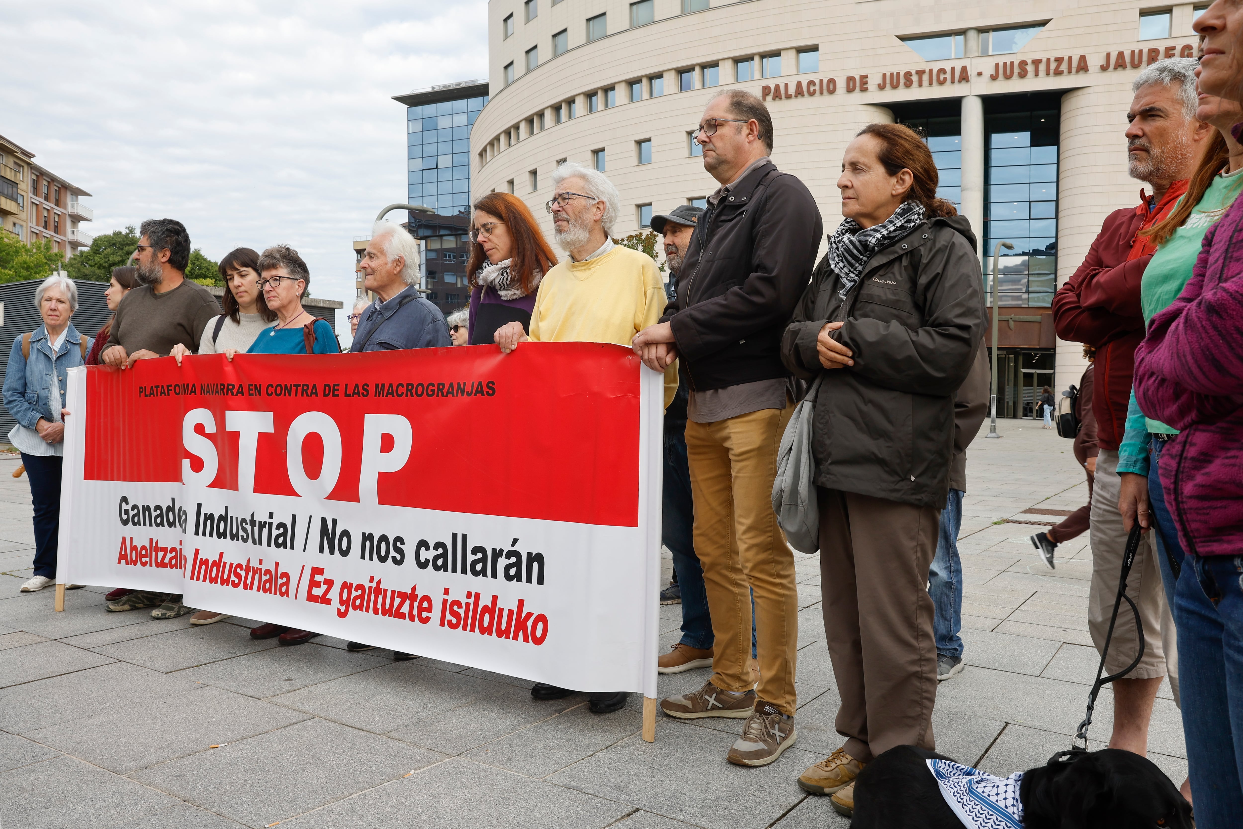Un grupo de personas de la Plataforma Navarra en contra de las macrogranjas se ha concentrado  ante el Palacio de Justicia de Navarra donde se celebra el juicio contra las personas integrantes del consejo de dirección de la macrogranja de Caparroso Valle de Odieta por delito medioambiental. EFE/ Villar López