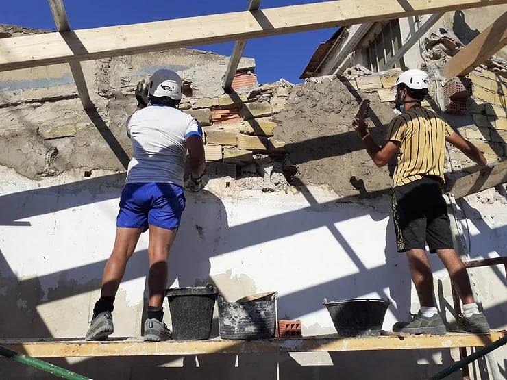 Participantes en el programa Asertos reformando los muros de una vivienda, en una imagen de archivo