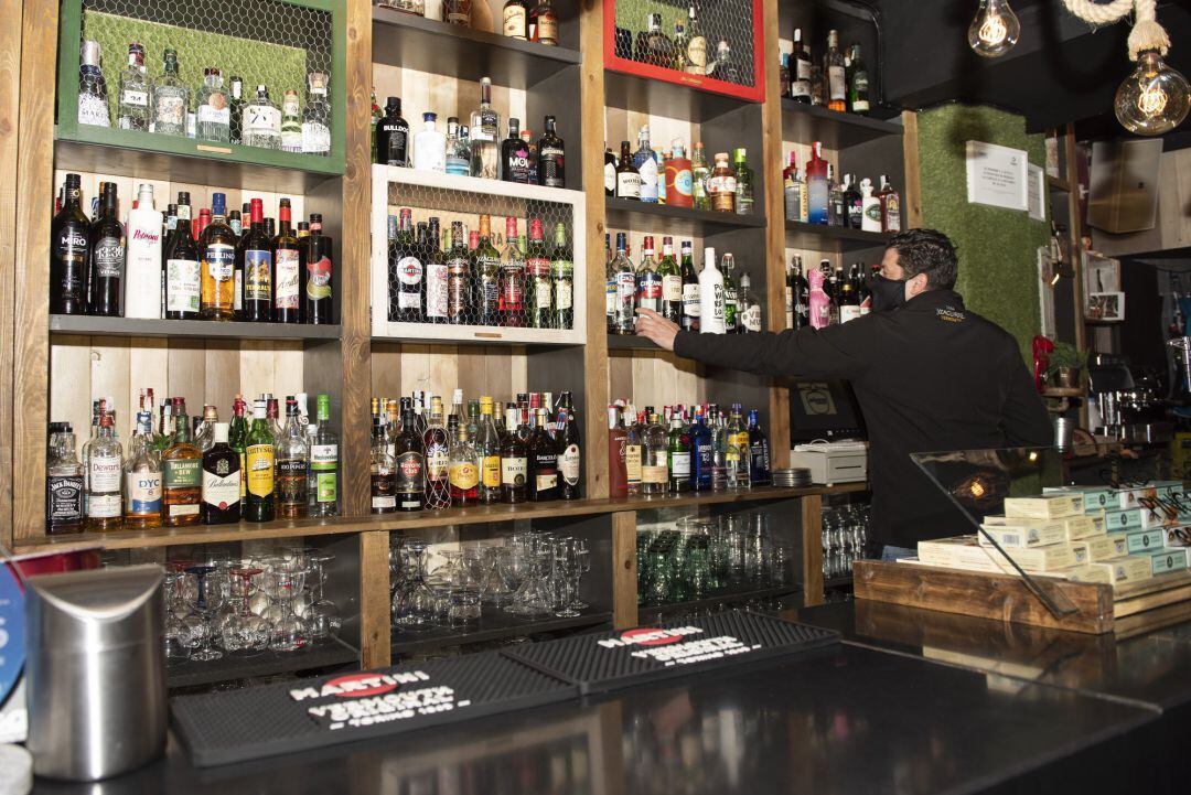 Un camarero trabaja en el interior de un bar