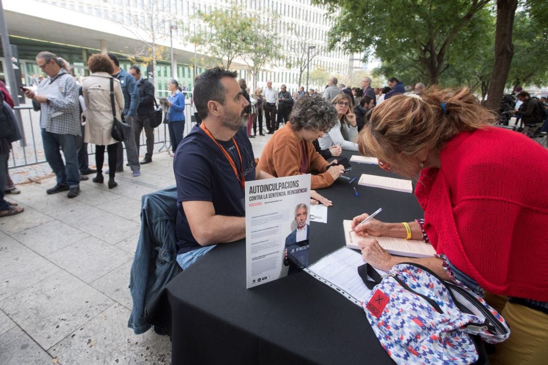 Decenas de ciudadanos esperan frente a la Ciudad de la Justicia, para entregar la documentación de autoinculpación en el marco de una campaña impulsada por la entidad Omnium Cultural.