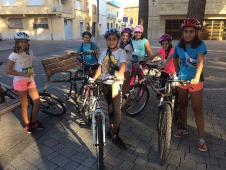 Un grupo de niñas pasean con su bicicleta bien protegidas por su casco de seguridad