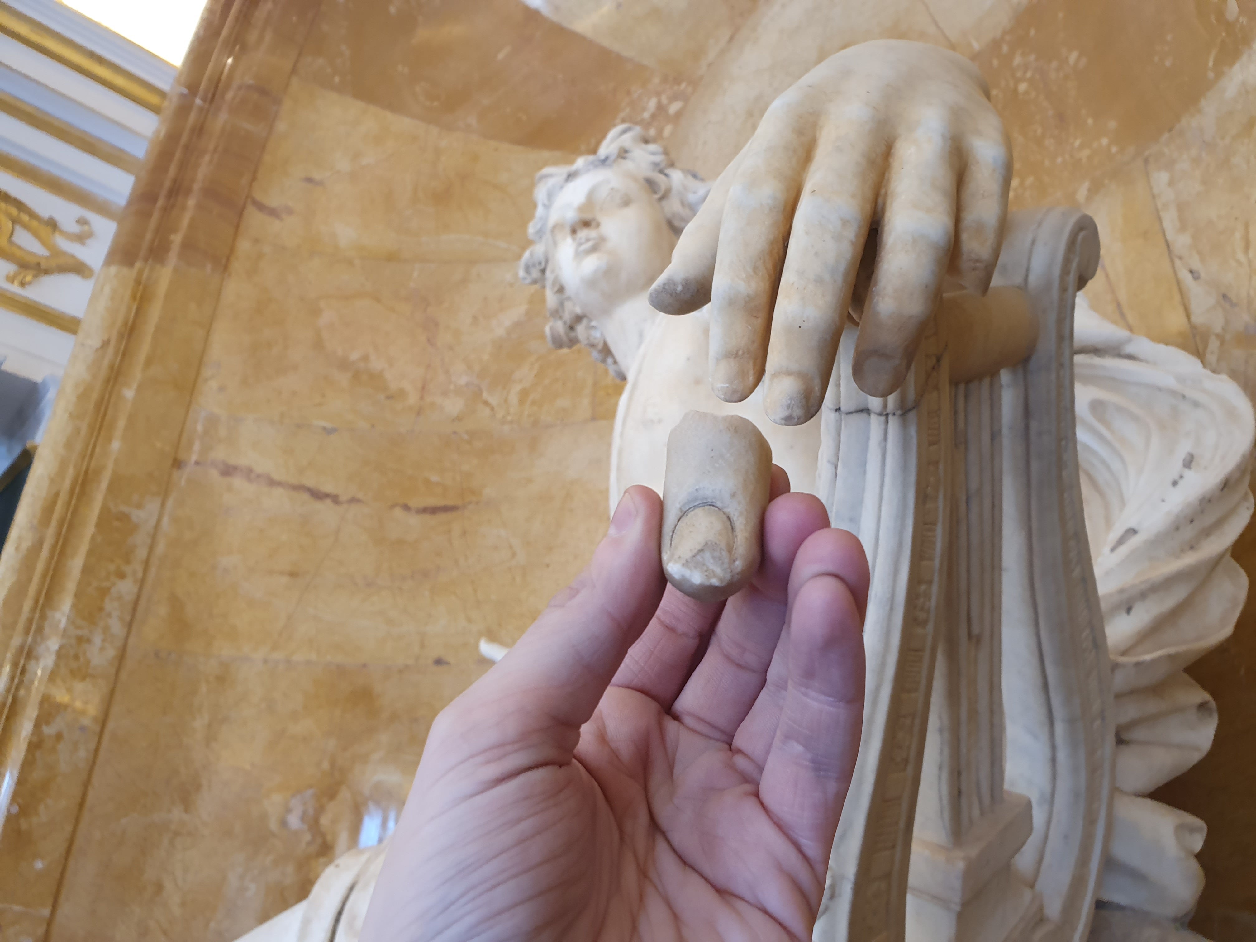 Dedo devuelto de la escultura de Apolo junto a la obra completa en la sala del Palacio Real de La Granja donde se encuentra junto a otras piezas de la colección de Cristina de Suecia (réplicas de vaciados en yeso de musas cuyos originales se exhiben en el Museo del Prado -Madrid-).