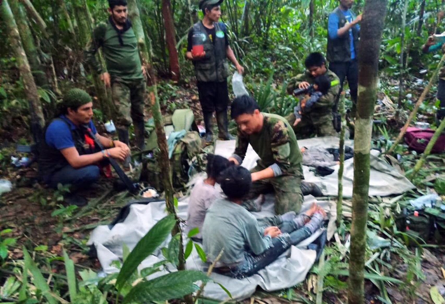 Fotografía cedida hoy por las Fuerzas Militares de Colombia que muestra a soldados e indígenas mientras atienden a los niños rescatados tras 40 días en la selva, en Guaviare (Colombia)