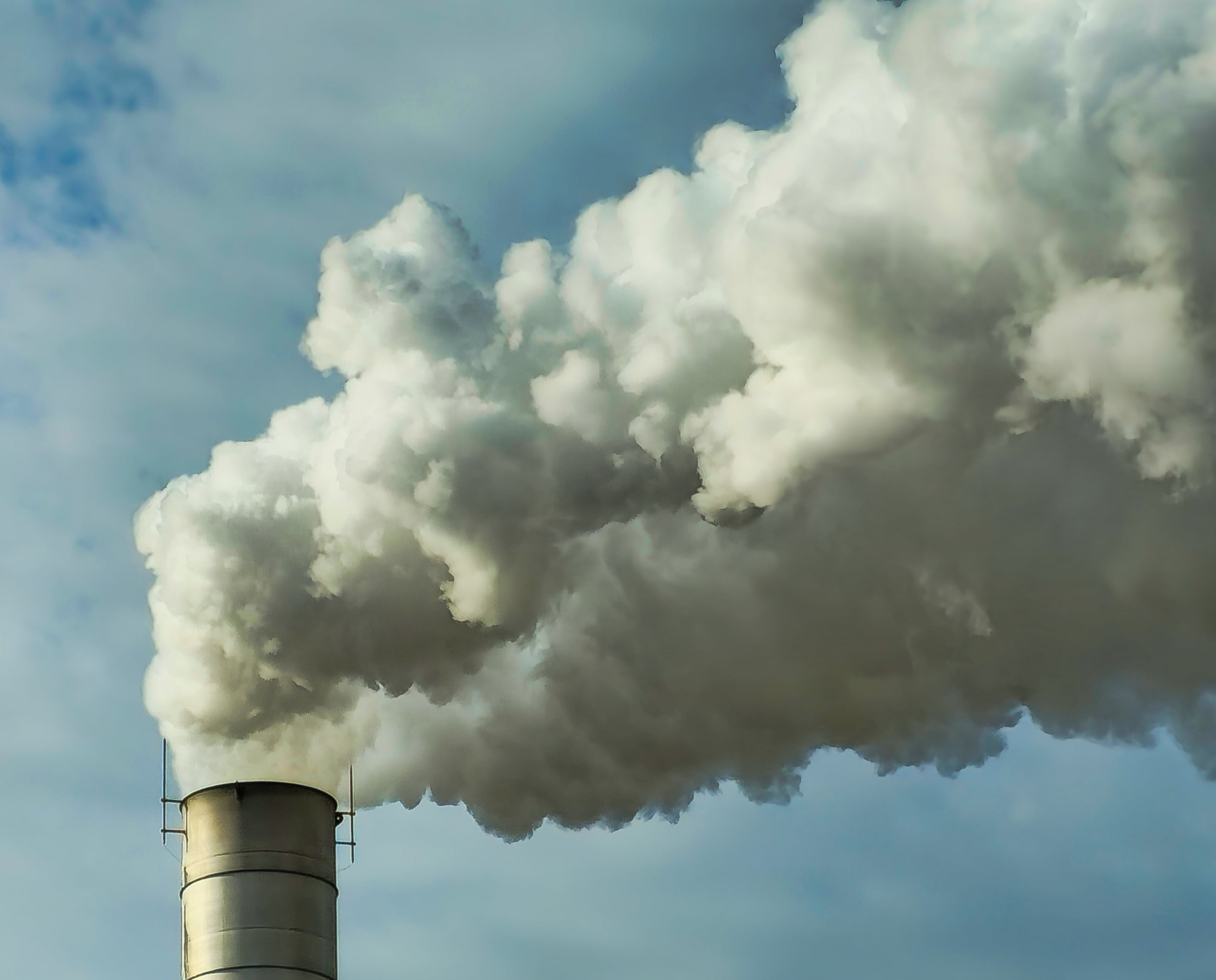 Steam rises from a factory chimney stack.