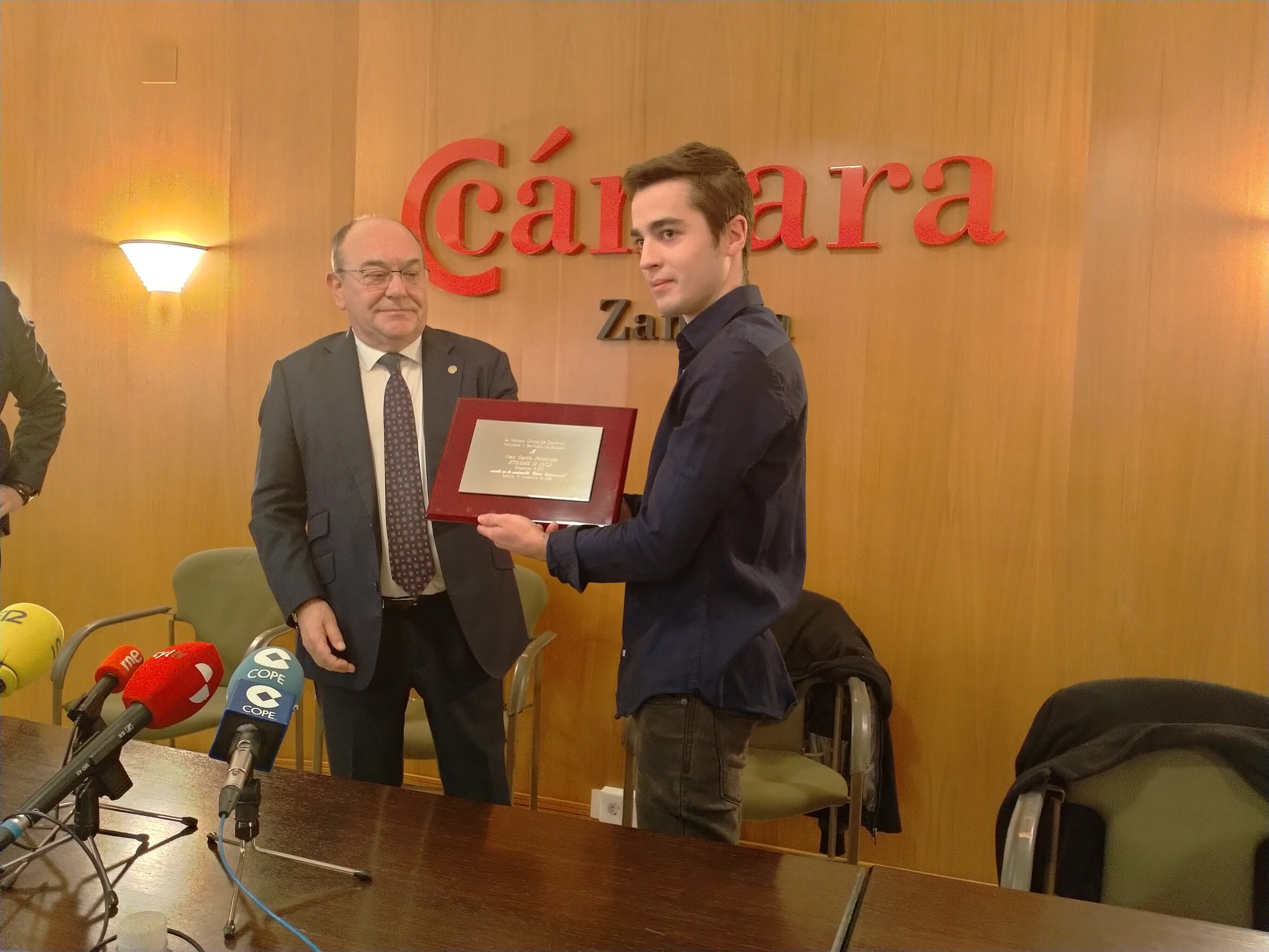 Enrique Oliveira, Presidente de la Cámara de Comercio de Zamora, hace entrega de una placa al joven emprendedor Iván García