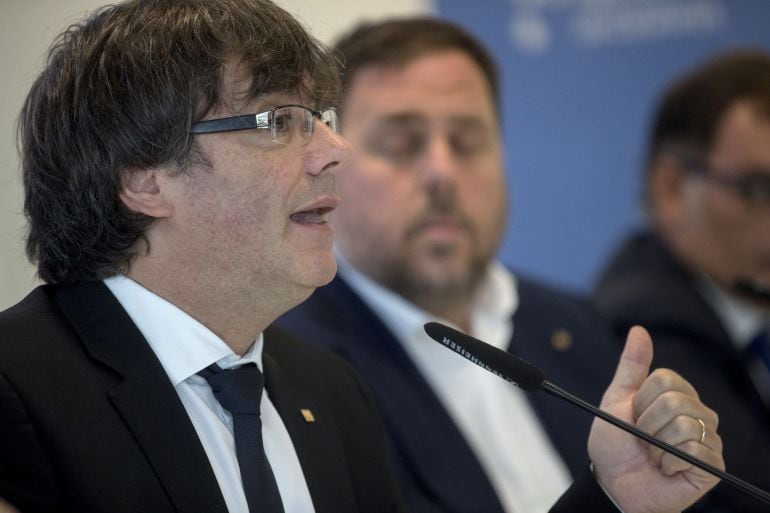 El presidente de la Generalitat, Carles Puigdemont (i), y el vicepresidente del Govern, Oriol Junqueras (d), durante la presentación en rueda de prensa la culminación del despliegue de la Agencia Tributaria de Cataluña, que desde el 1 de septiembre asume 