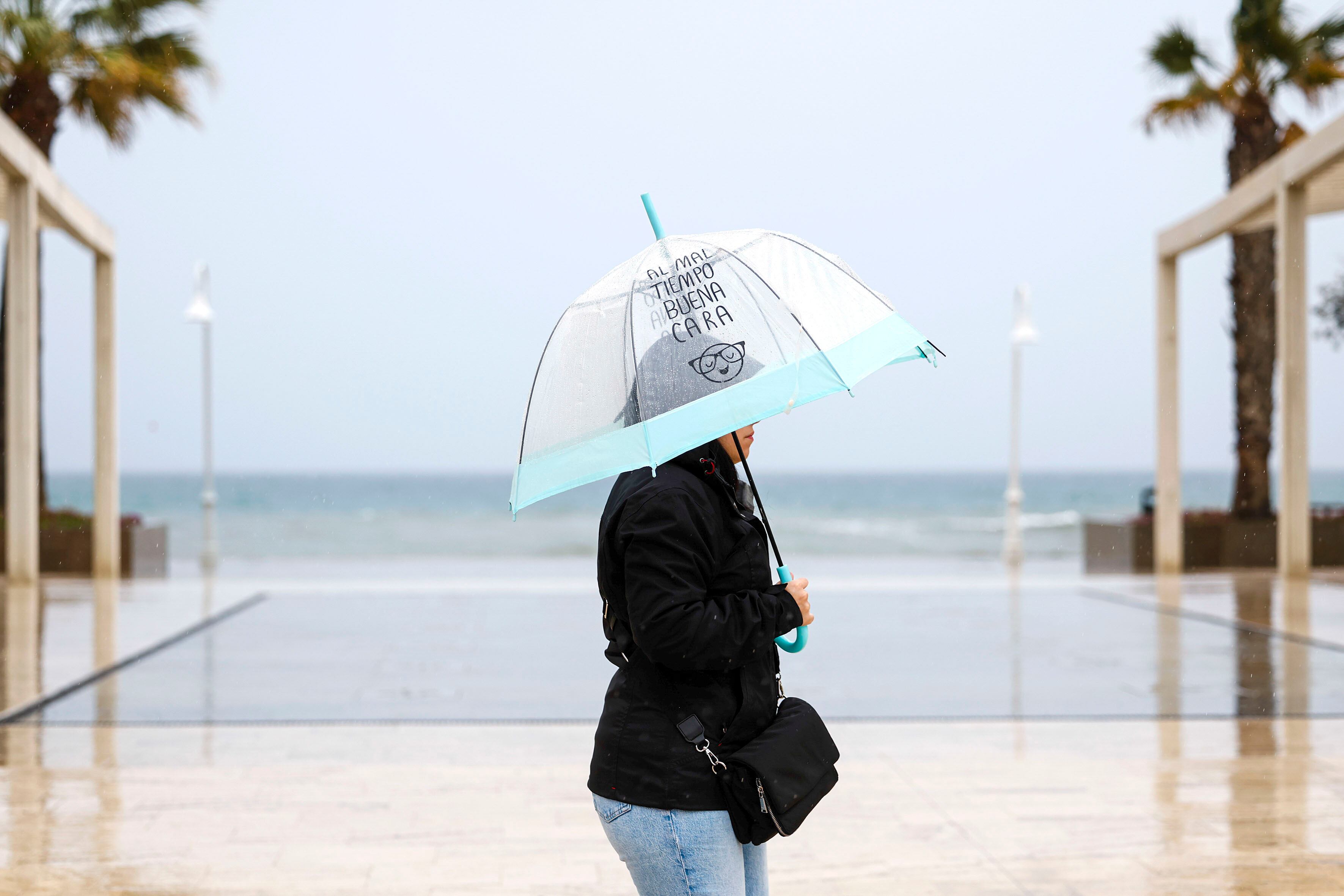 RINCÓN DE LA VICTORIA (ANDALUCÍA), 28/02/2025.- Un mujer se protege de la lluvia con su paraguas, este viernes, en el Rincón de la Victoria (Málaga). La Dirección General de Protección Civil y Emergencias alerta a la población de chubascos intensos especialmente en el sur y el Mediterráneo en las próximas horas y la llegada de una masa de aire polar que dejará nevadas el fin de semana, especialmente en el norte, en cotas de hasta 700 metros.EFE/ Jorge Zapata