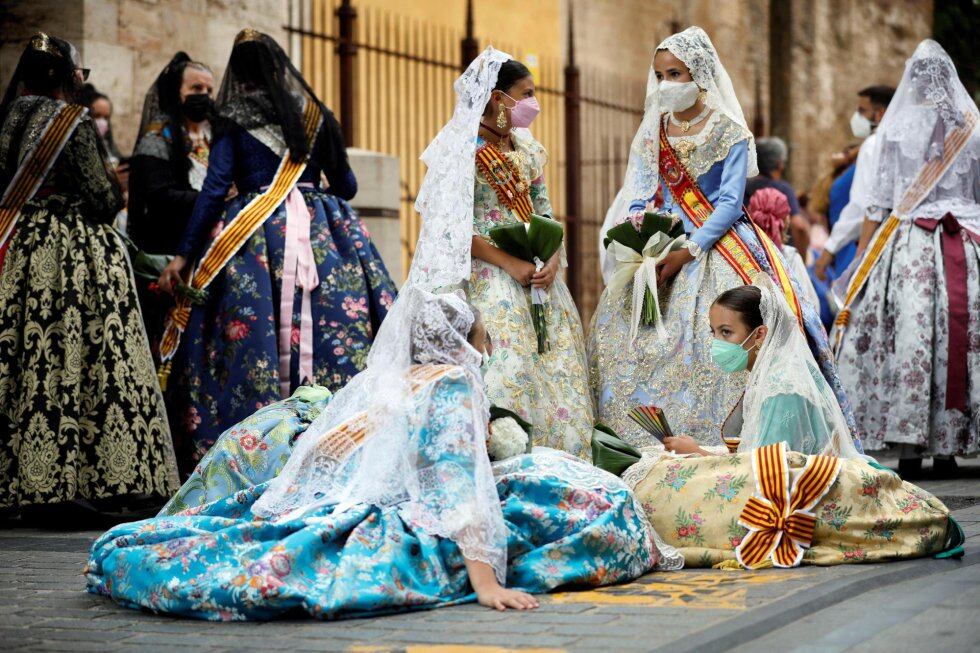 Un grupo de falleras se toma un descanso al inicio de la Ofrenda a la Virgen durante las Fallas de 2021, celebradas en septiembre