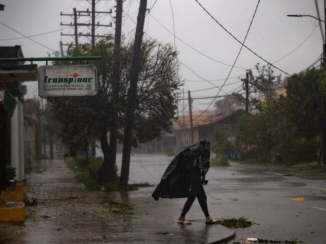 Un hombre camina en una calle con destrozos dejados por el paso del huracán Ian en Pinar del Río (Cuba).