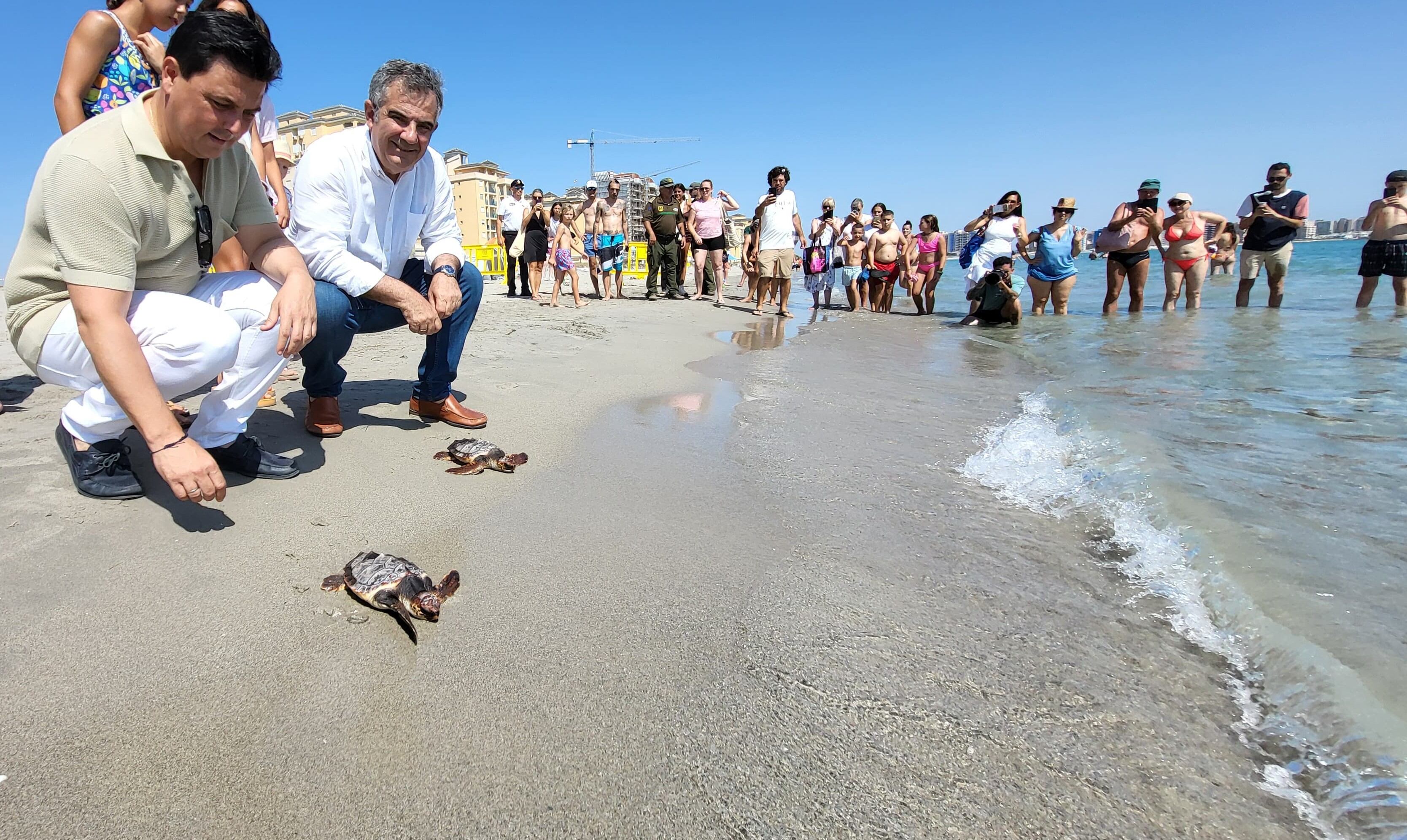 El consejero de Medio Ambiente, Universidades, Investigación y Mar Menor, Juan María Vázquez, con al alcalde de San Javier, José Miguel Luengo, durante la liberación de las tortugas boba.