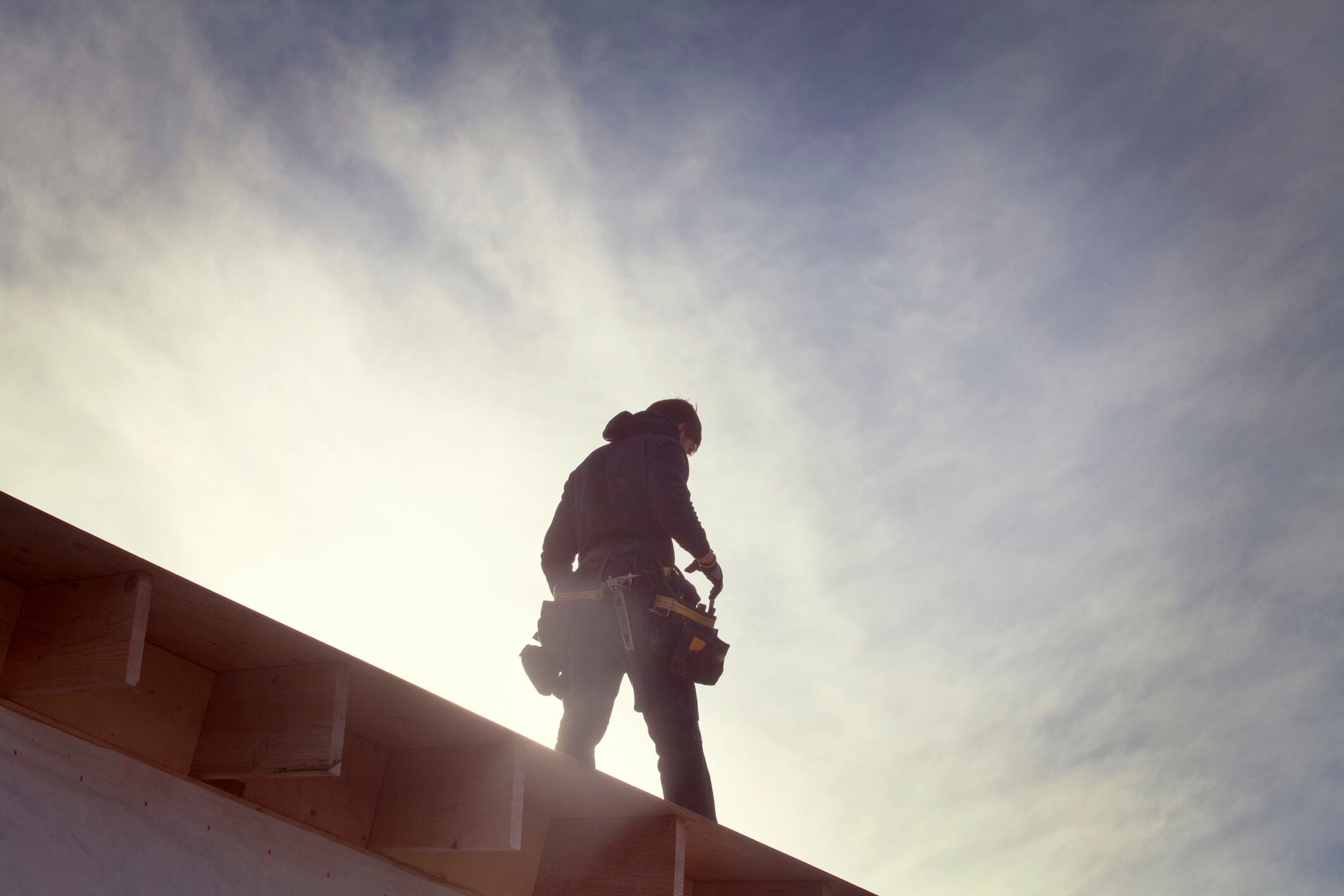 Un trabajador camina por un tejado durante la obra de un edificio