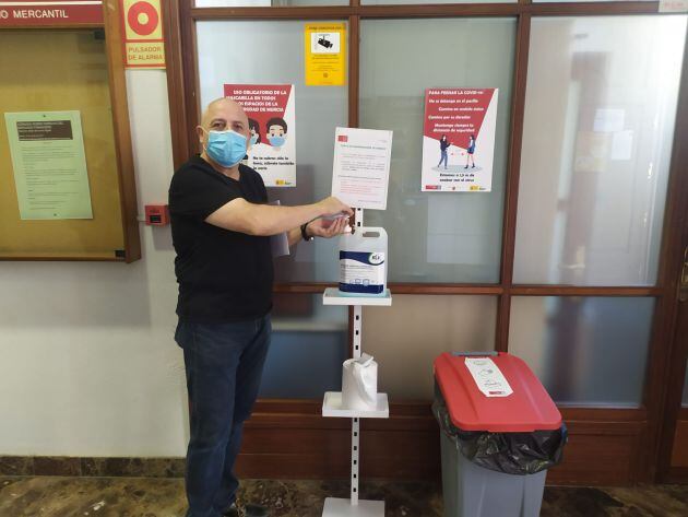 Un profesor de la UMU utiliza uno de los dispensadores de gel hidroalcóholico instalados en el campus de La Merced