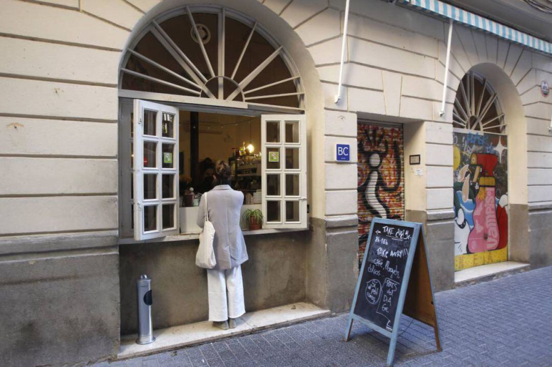 Una mujer en la ventana de una cafetería en Palma.