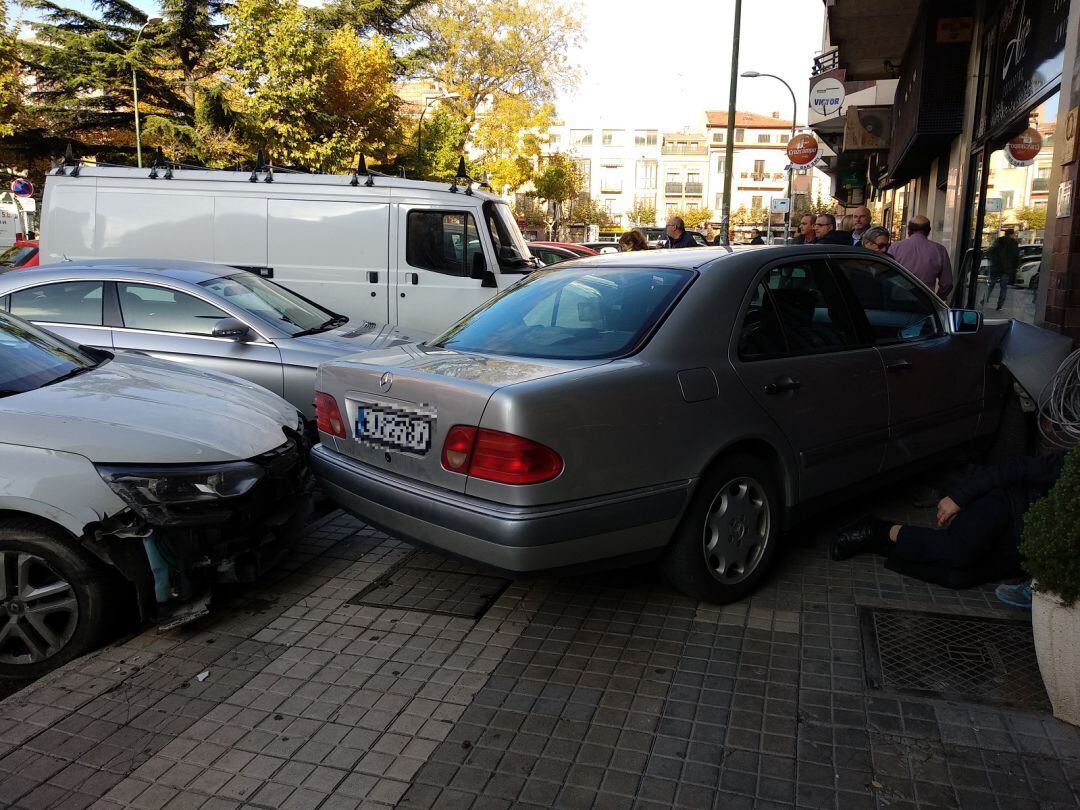 Vehículo empotrado en la pared y, al lado, la persona accidentada a la espera de ser atendida