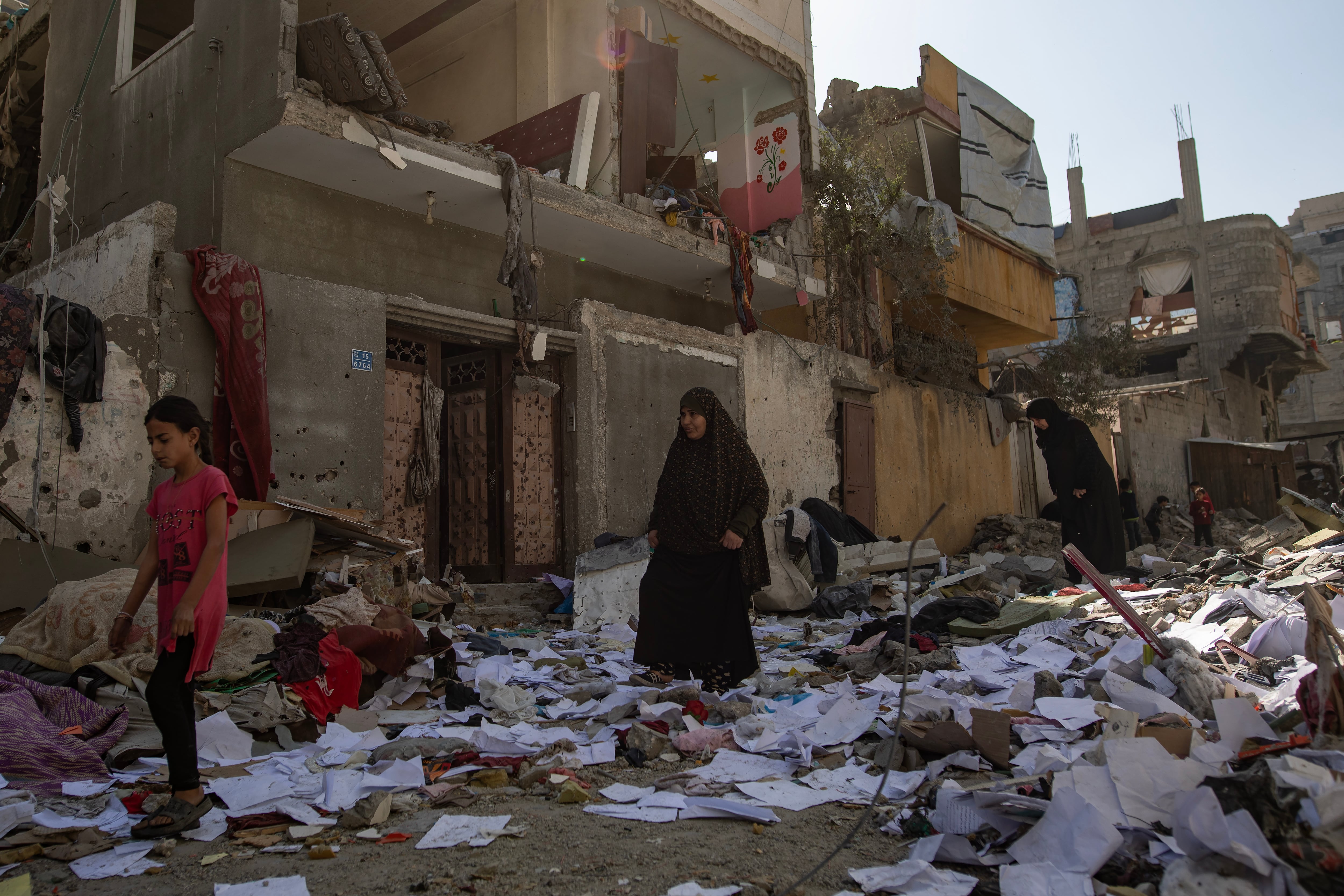 Ciudadanos palestinos caminan sobre las ruinas de los edificios que han dejado los últimos ataques israelíes sobre la Franja. EFE/EPA/HAITHAM IMAD