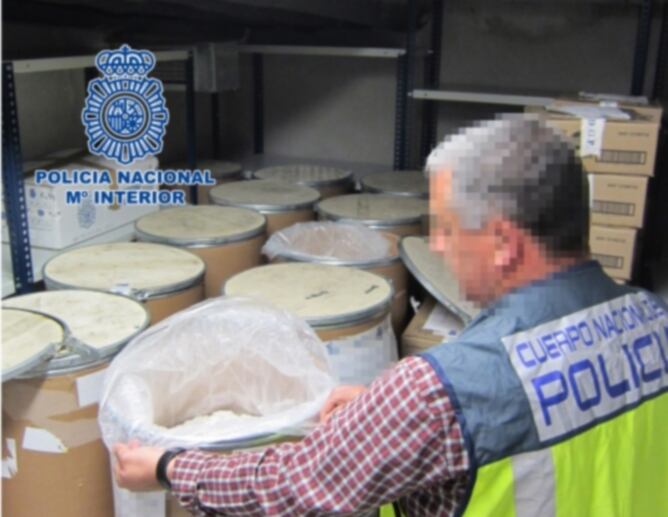Un agent de la policia espanyola amb els bidons intervinguts on hi havia la substància per fabricar èxtasi
