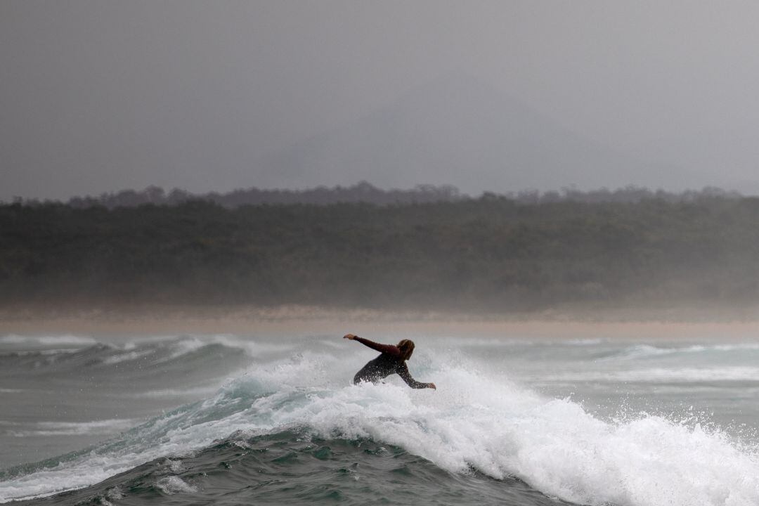 A surfer rides a wave in Bengello beach in Broulee, Australia January 14, 2020. Picture taken January 14, 2020. REUTERS Alkis Konstantinidis 