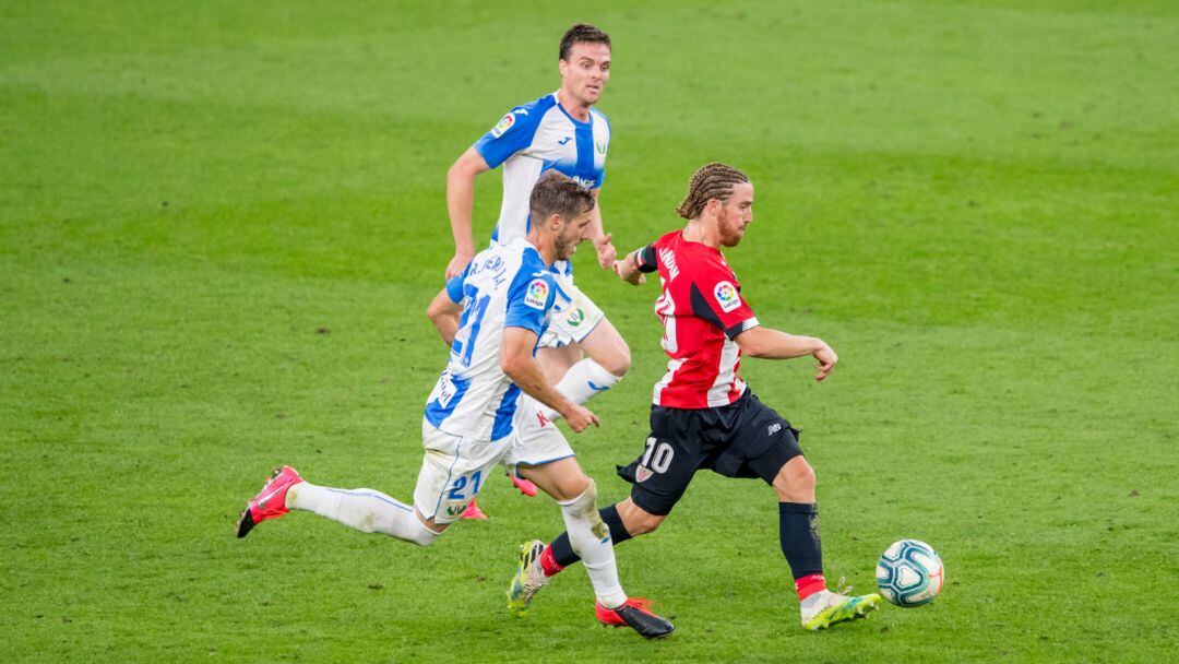 Iker Muniain conduce el balón ante dos jugadores del Leganés