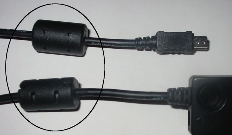 Dos núcleos de ferrita colocados en dos cables.