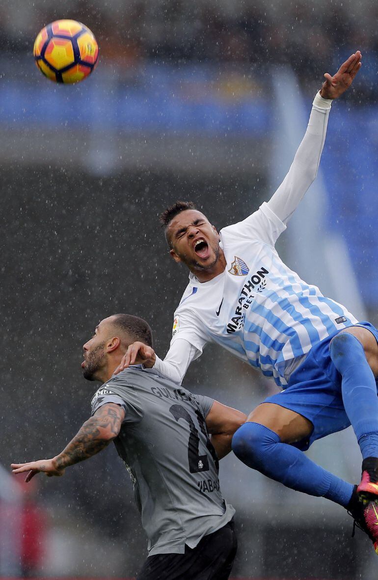 El centrocampista brasileño del Deportivo Guilherme dos Santos (i) lucha por el balón ante el delantero marroquí del Málaga Youseff En-Nesyri durante la decimotercera jornada de la Liga de Primera División en el estadio de La Rosaleda, en Málaga.