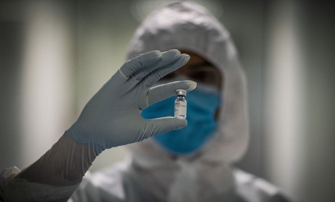 Un científico con una dosis de Pfizer contra la COVID-19.