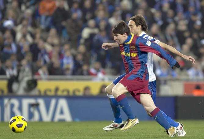 El delantero argentino del F. C. Barcelona Lionel Messi pelea un balón con el centrocampista del RCD Espanyol Raúl Baena