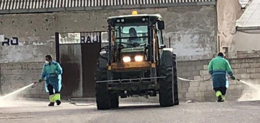 Operarios municipales limpian y desinfectan las calles de Pegalajar con la ayuda de un tractor.