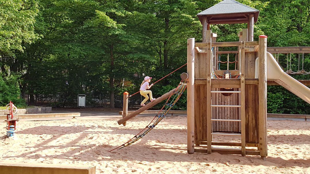 Una niña juega en un parque infantil. 