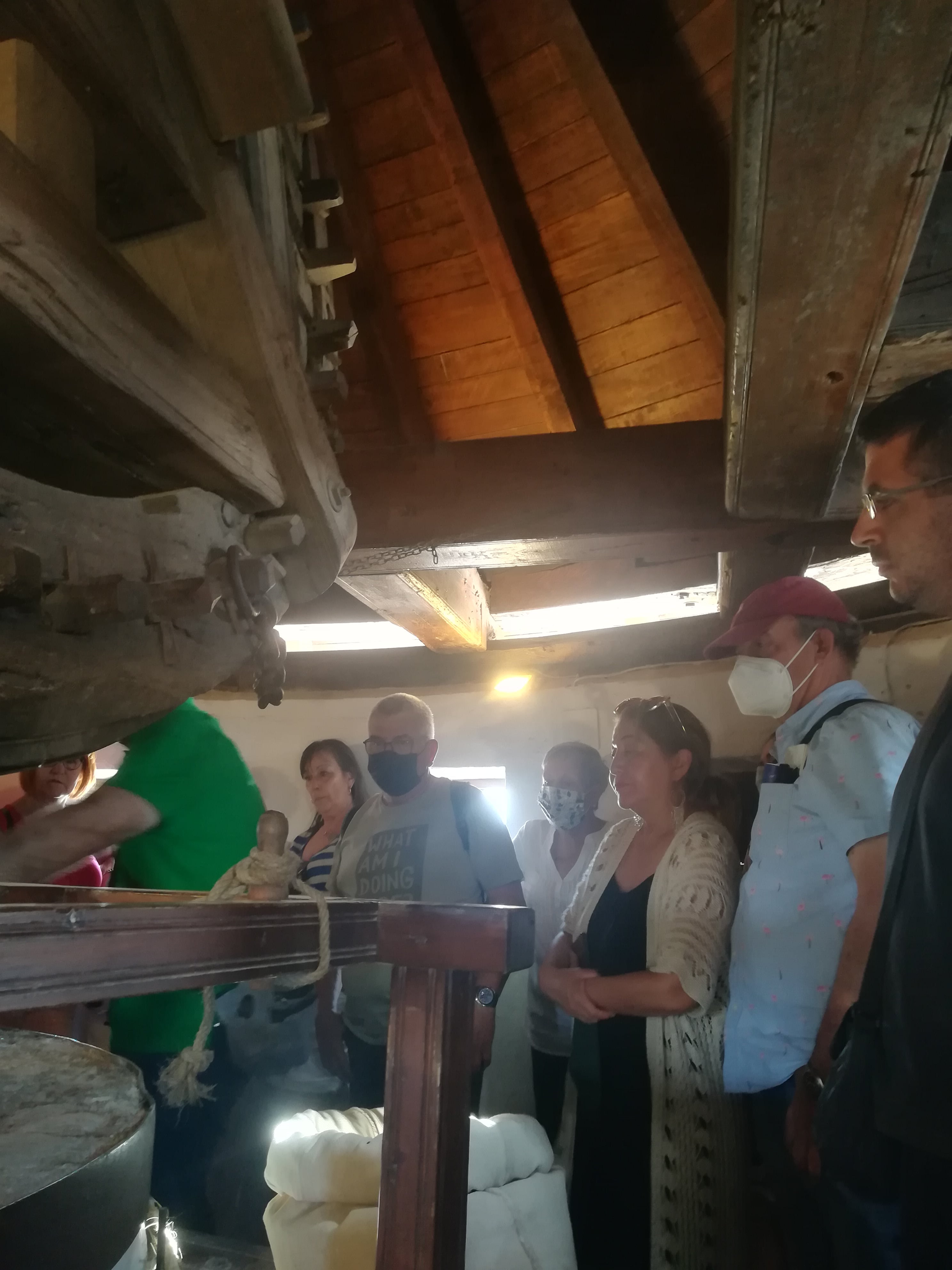 Los viajeros del Tren de los Molinos escuchando las explicaciones sobre el funcionamiento de los molinos harineros