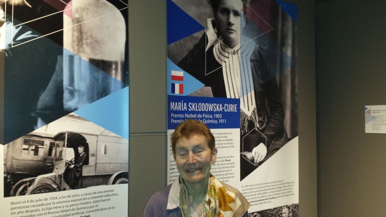 La nieta de la científica Marie Curie posa bajo un panel de la exposición &quot;Mujeres Nobel&quot; dedicado a su abuela y que puede verse en el Museo Nacional de Ciencias Naturales, en Madrid. 