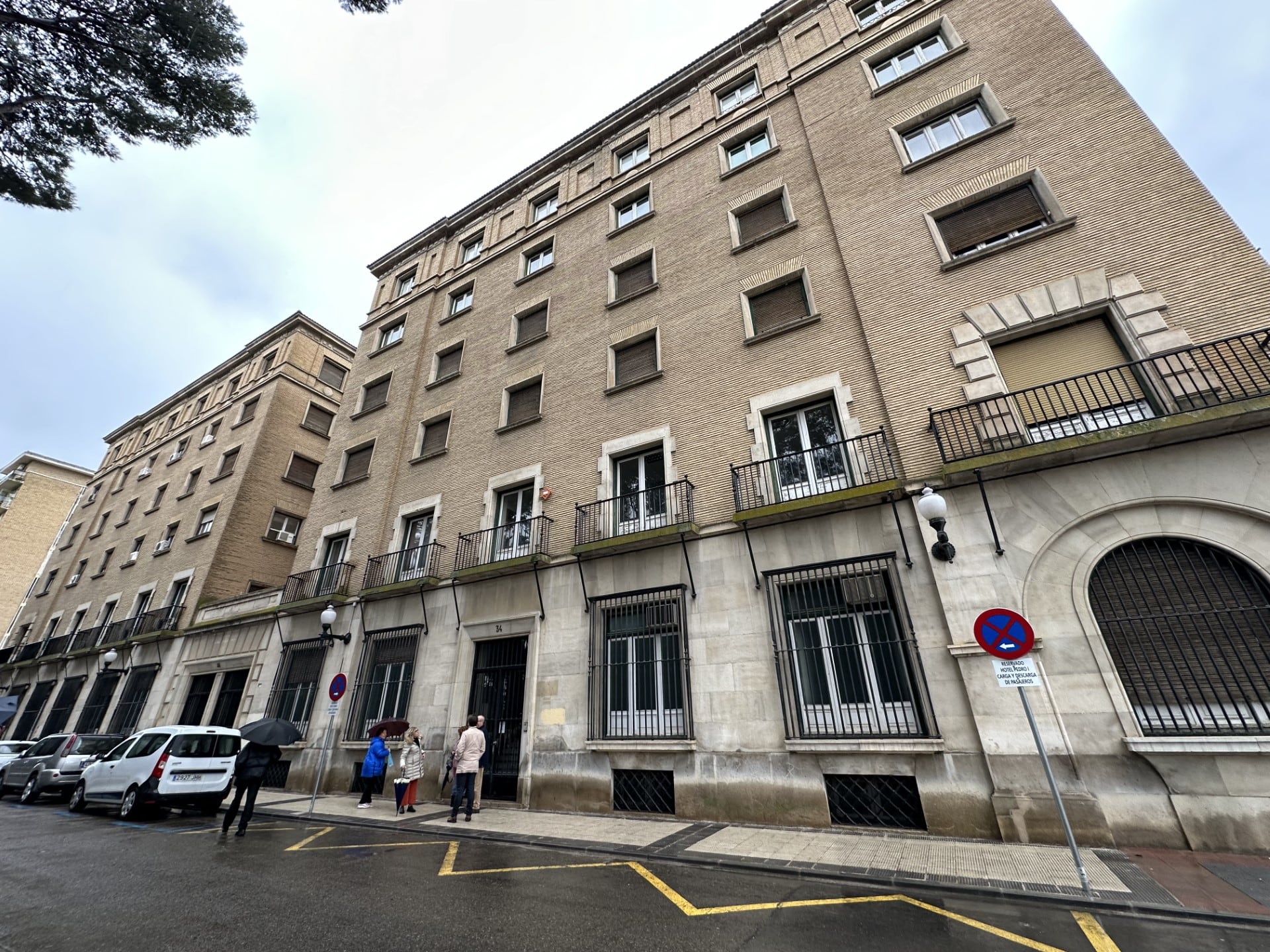 Edificio de la Tesorería Seguridad Social en Huesca con representantes del grupo municipal socialista frente a la puerta