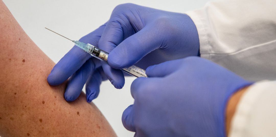 Un profesional sanitario con una jeringuilla en sus manos.