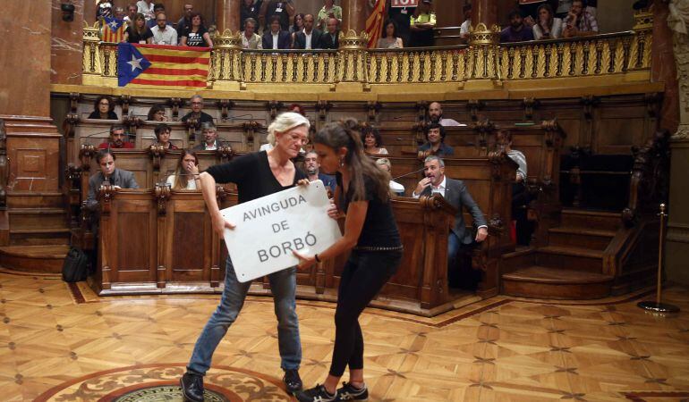 GRA113 BARCELONA, 07/09/2015.- Las concejales de la CUP, Maria José Lecha (i) y Maria Rovira, con una placa de la "Avinguda de Borbó (Avenida de Borbón)", como protesta a la presencia de referencias a la monarquía en las calles de Barcelona, durante el pleno extraordinario, solicitado por los grupos de CiU, ERC, y CUP, para debatir y votar si la capital catalana se adhiere a la Asociación de Municipios por la Independencia. EFE/Toni Albifr