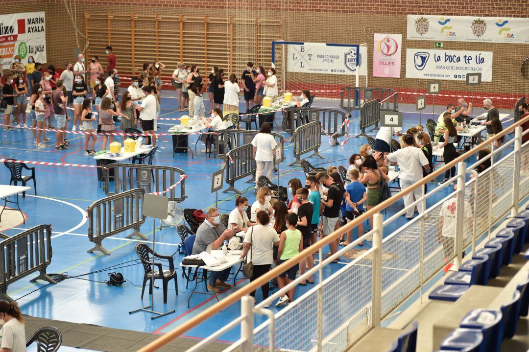 Un conjunto de jóvenes esperan dentro de las instalaciones del Pabellón Jara Carrillo para vacunarse de la primera dosis de la vacuna Moderna, a 3 de agosto de 2021, en Alcantarilla, Murcia (España). La Región de Murcia empezó el pasado día 1 a vacunar al