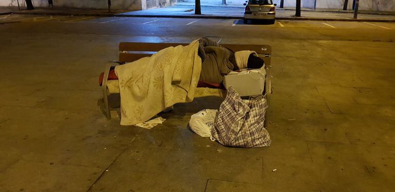 Una persona sin hogar pasa la noche frente a la estación de autobuses de Granada