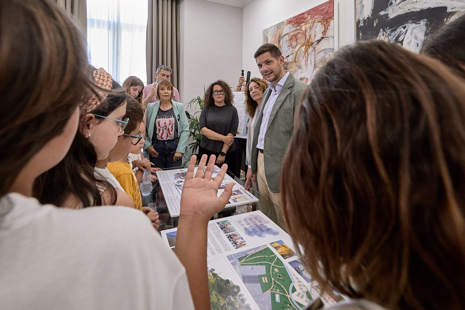 Los niños del Consell dels Jove observando cómo será el parque.