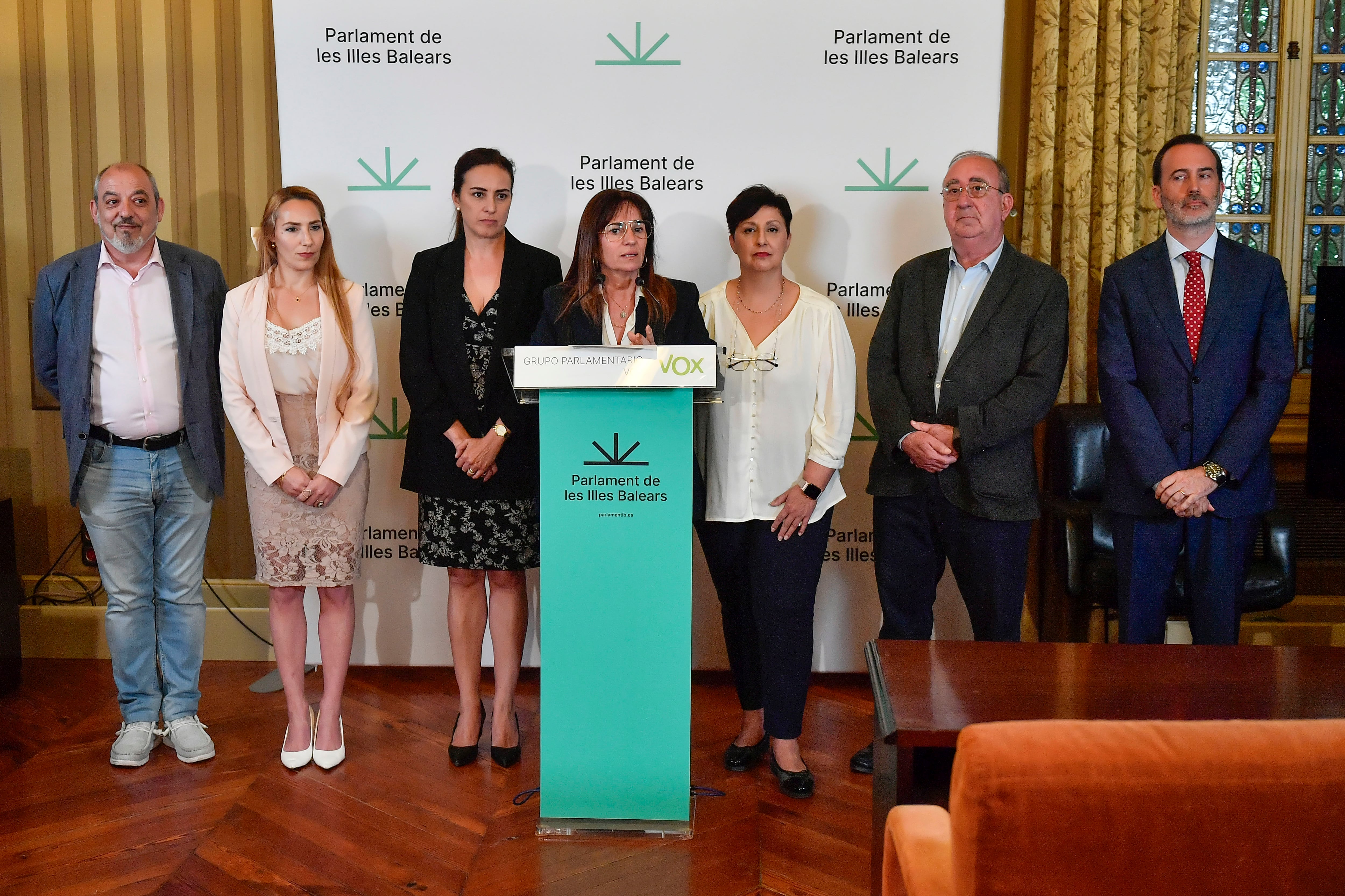 Manuela Cañadas (c) junto a María José Verdú (3d), comparecen en rueda de prensa junto a todos sus compañeros diputados en el Parlament, tras ser nombradas en abril como nueva portavoz y portavoz adjunta de Vox en el Parlament balear, respectivamente, tras la decisión de Idioa Ribas  (3i) y Sergio Rodríguez (i) de dimitir de sus cargos como portavoz y portavoz adjunto de Vox, respectivamente. EFE/ Miquel A. Borràs