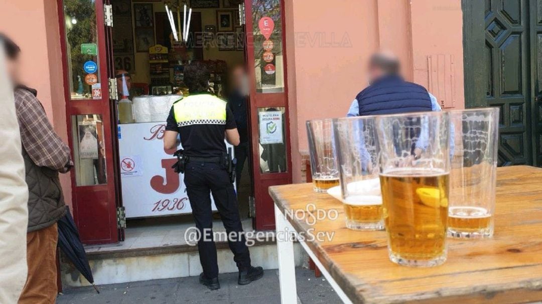 Un agente de la Policía Local conversa con el encargado del Bar Jota