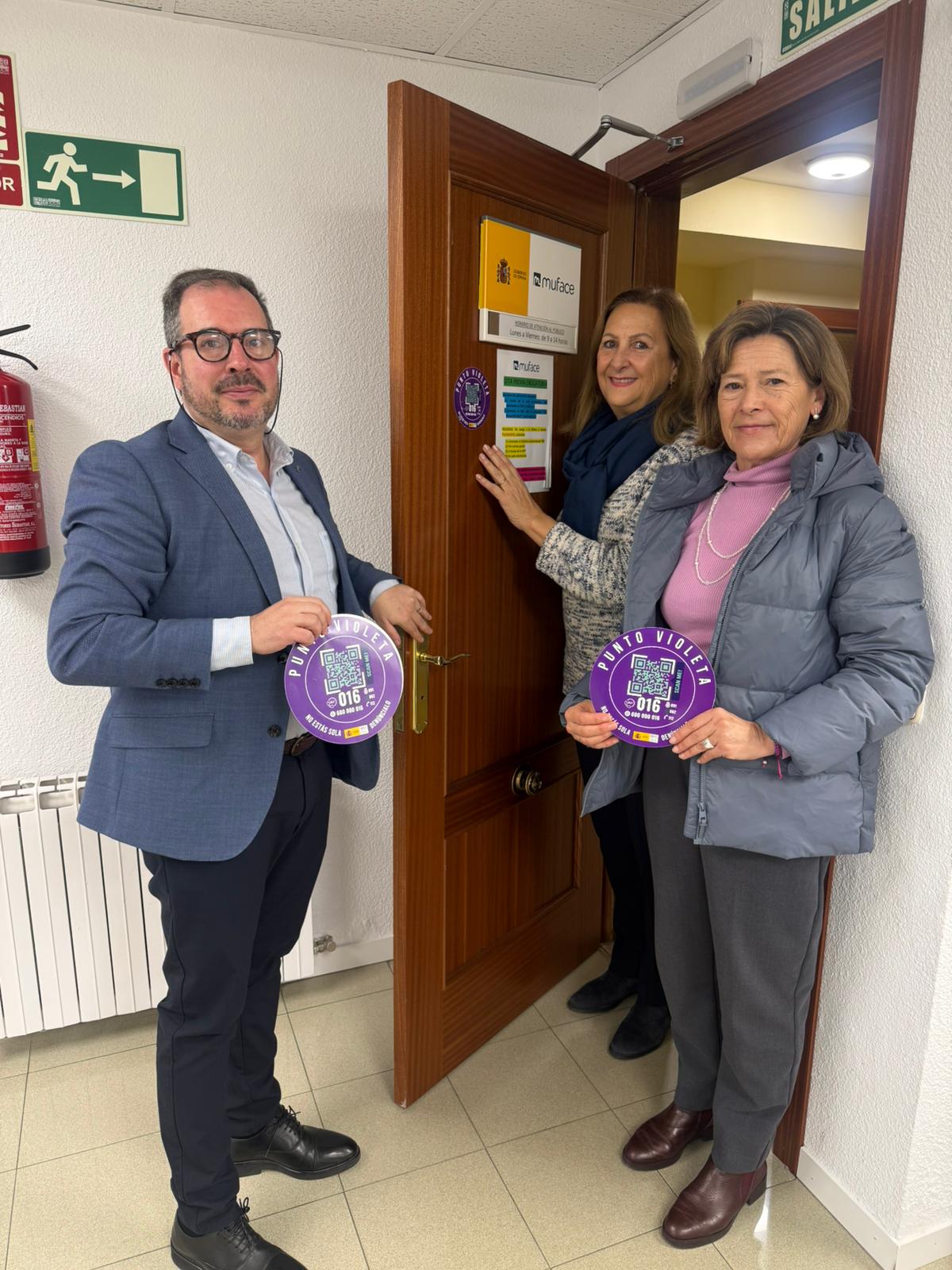 La subdelegada del Gobierno, Marian Rueda, y el director de MUFACE en Segovia, Víctor Cristóbal García y la jefa de la Unidad de Violencia sobre la Mujer de la Subdelegación del Gobierno, Carmen Meléndez, colocan la pegatina de Punto Violeta