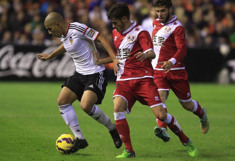 Feghouli, autor de dos goles, conduce el balón ante dos jugadores del Rayo.