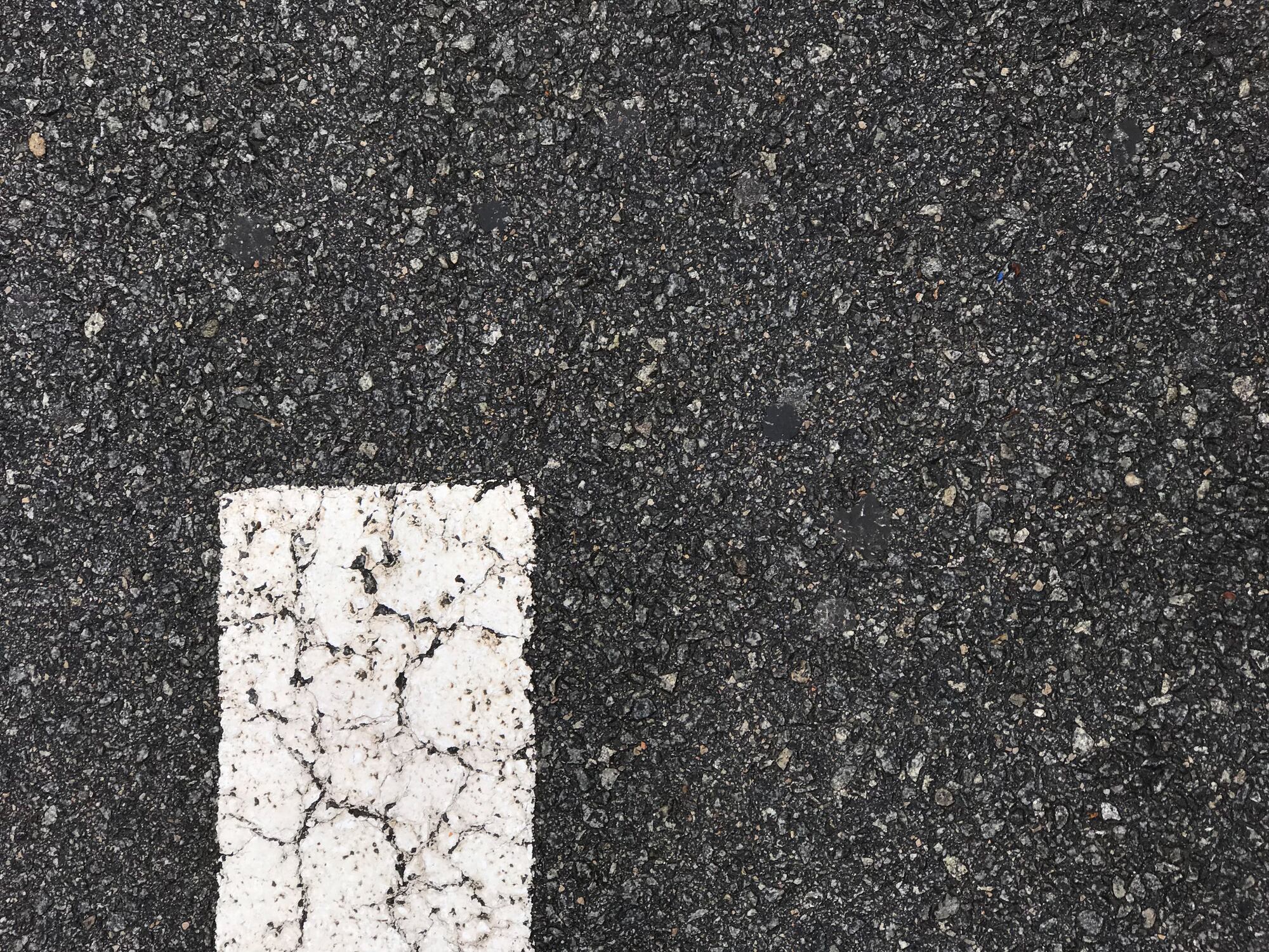 Una señal blanca impresa en el pavimento de una carretera