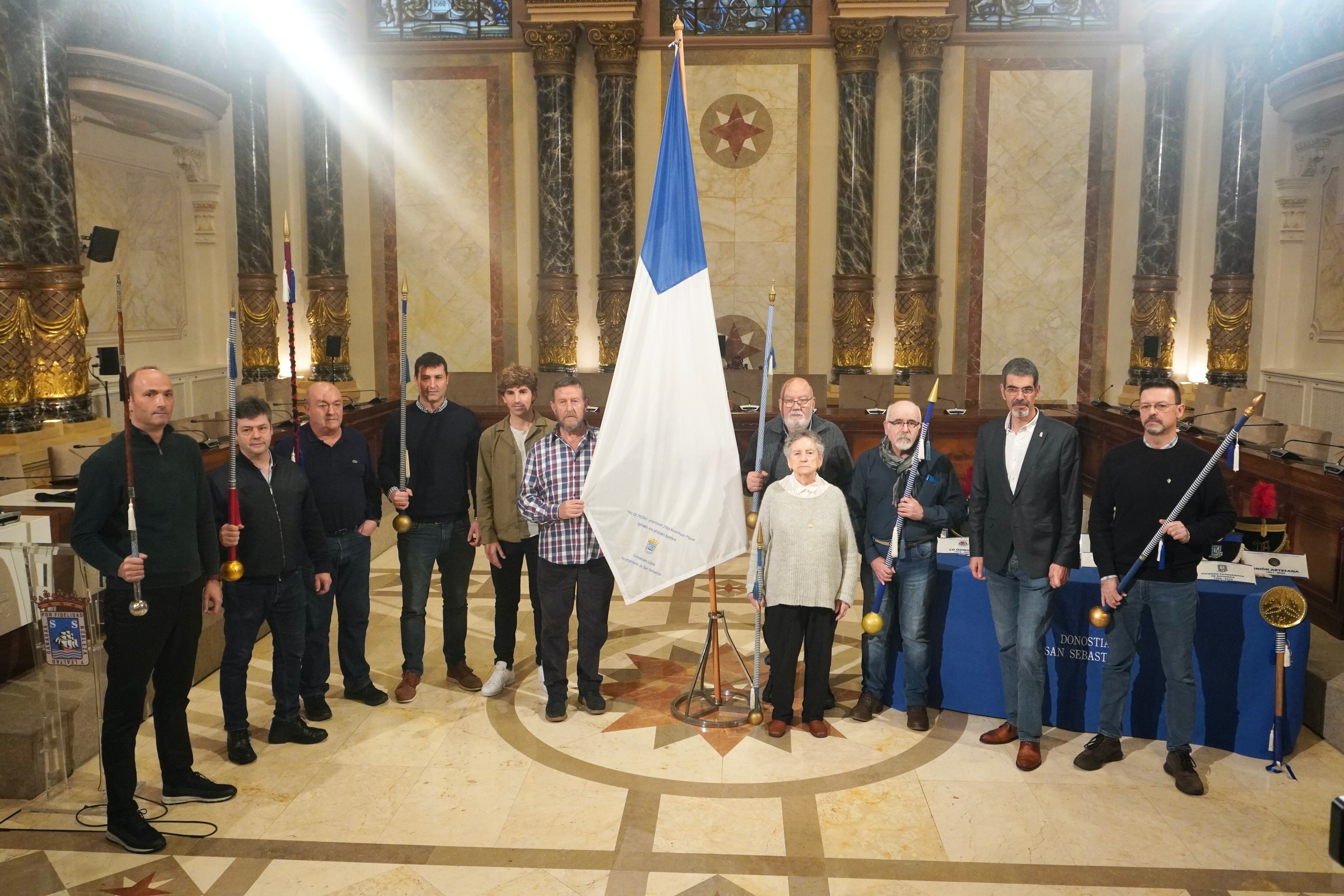 El alcalde, el concejal de cultura, y los tambores mayores de varias tamborradas en el Salón de plenos del Ayuntamiento de San Sebastián en la presentación de la fiesta patronal