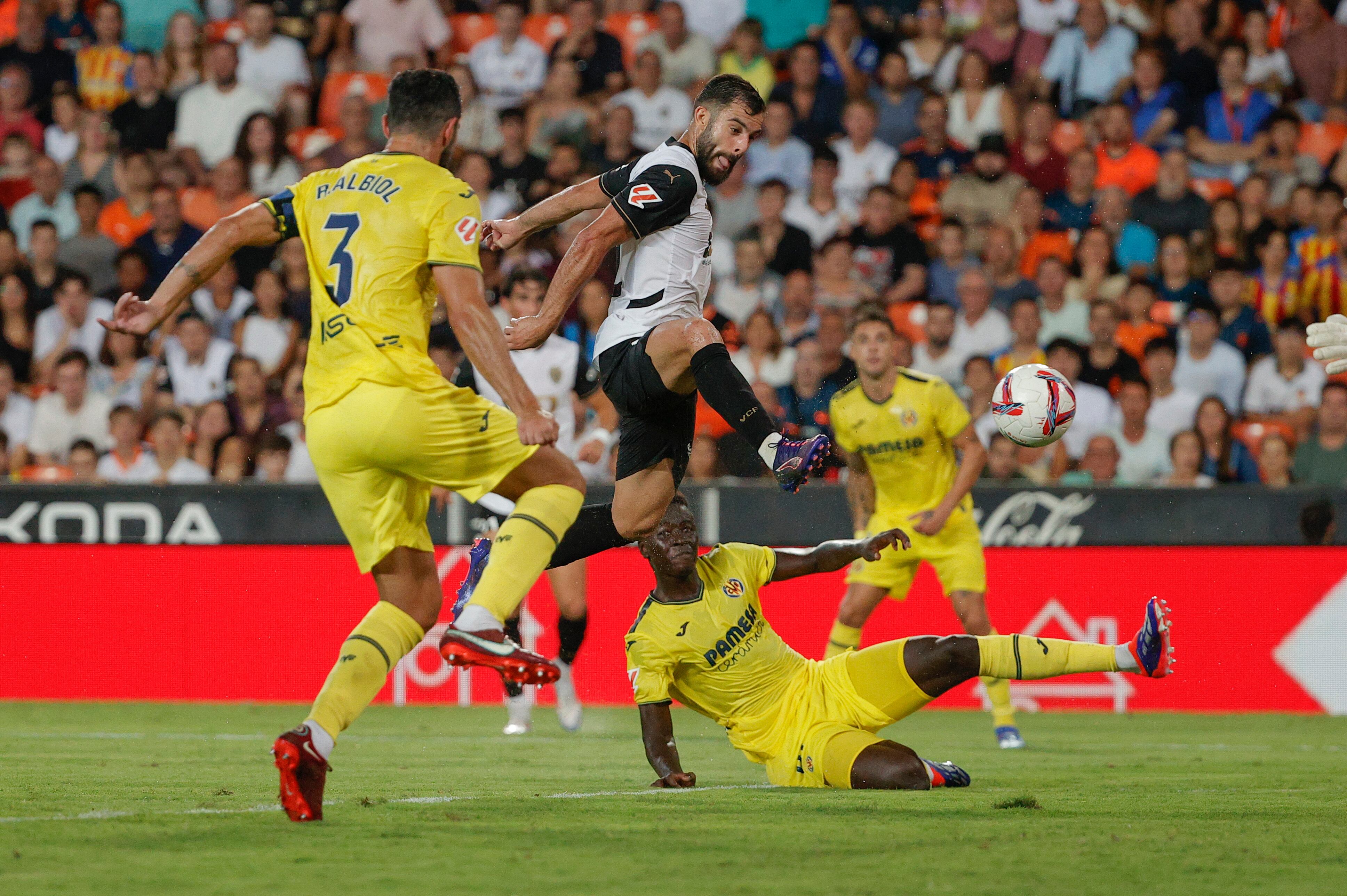 El centrocampista del Valencia Luis Rioja (c) intenta rematar entre los jugadores del Villarreal, durante el encuentro de la cuarta jornada de LaLiga entre el Valencia CF y el Villarreal, este sábado en el estadio de Mestalla, Valencia. EFE/ Manuel Bruque