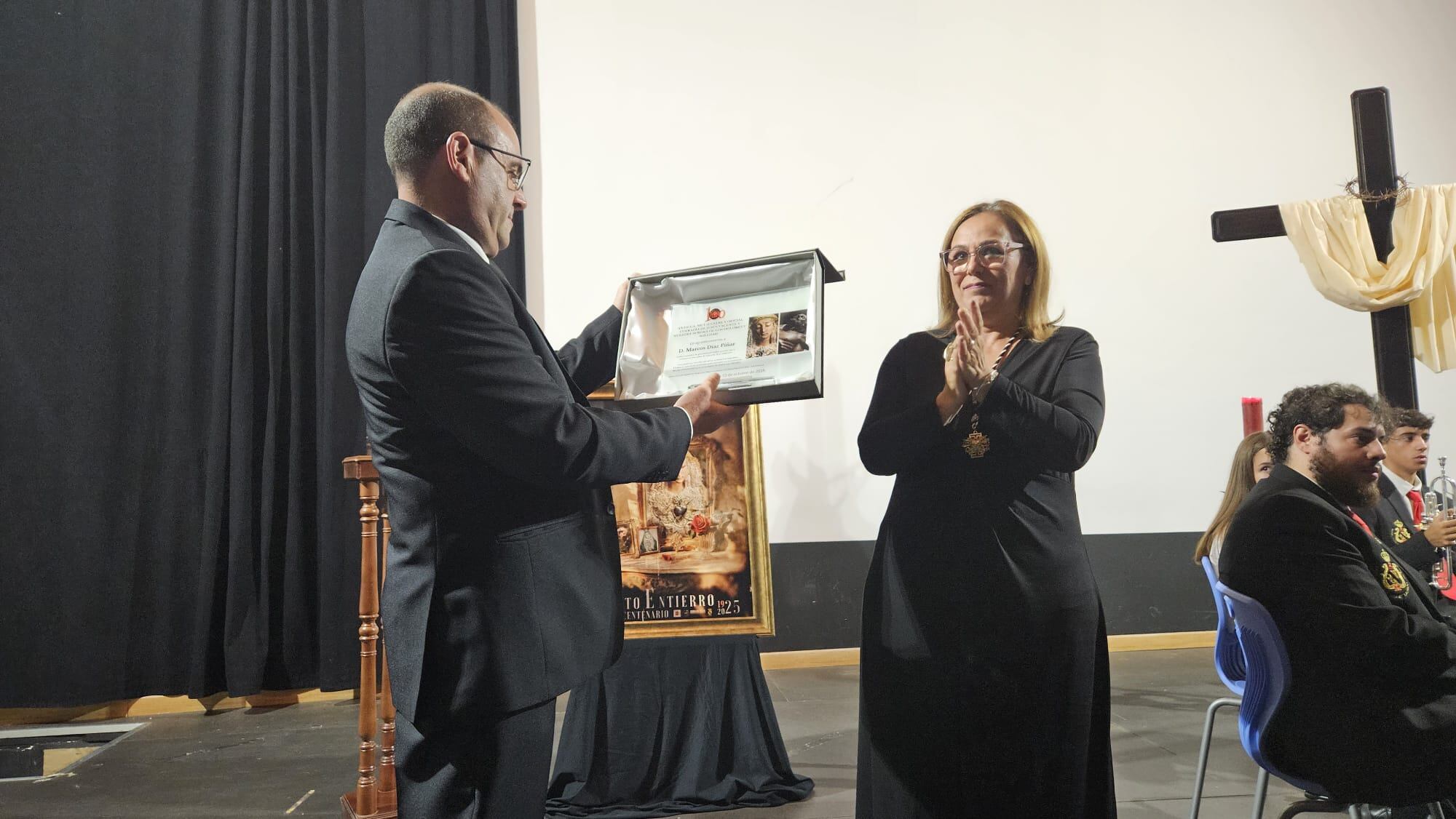 El pregonero del Centenario, Marco Díaz Píñar, recoge la placa conmemorativa de manos de la Hermana Mayor
