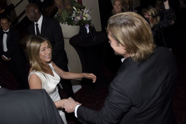 Aniston lucía un traje de noche blanco y Pitt traje negro de chaqueta con camisa blanca.