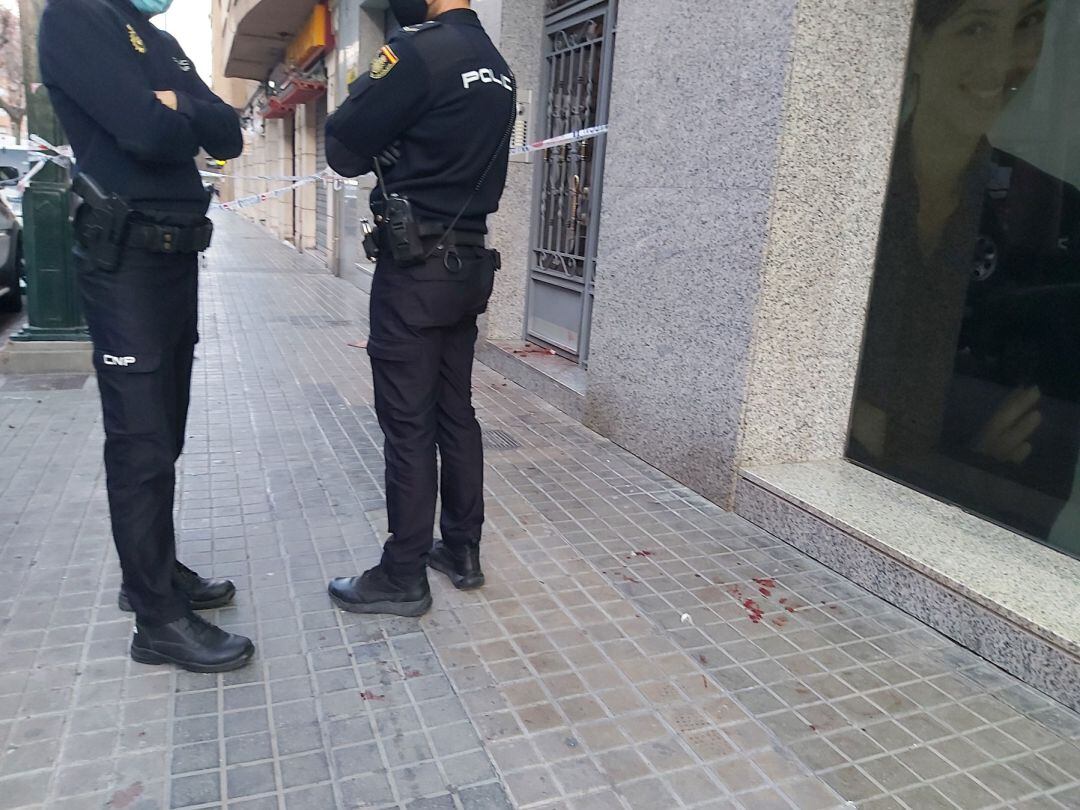 Dos efectivos de la Policía Nacional en la puerta de la vivienda donde se han producido los hechos